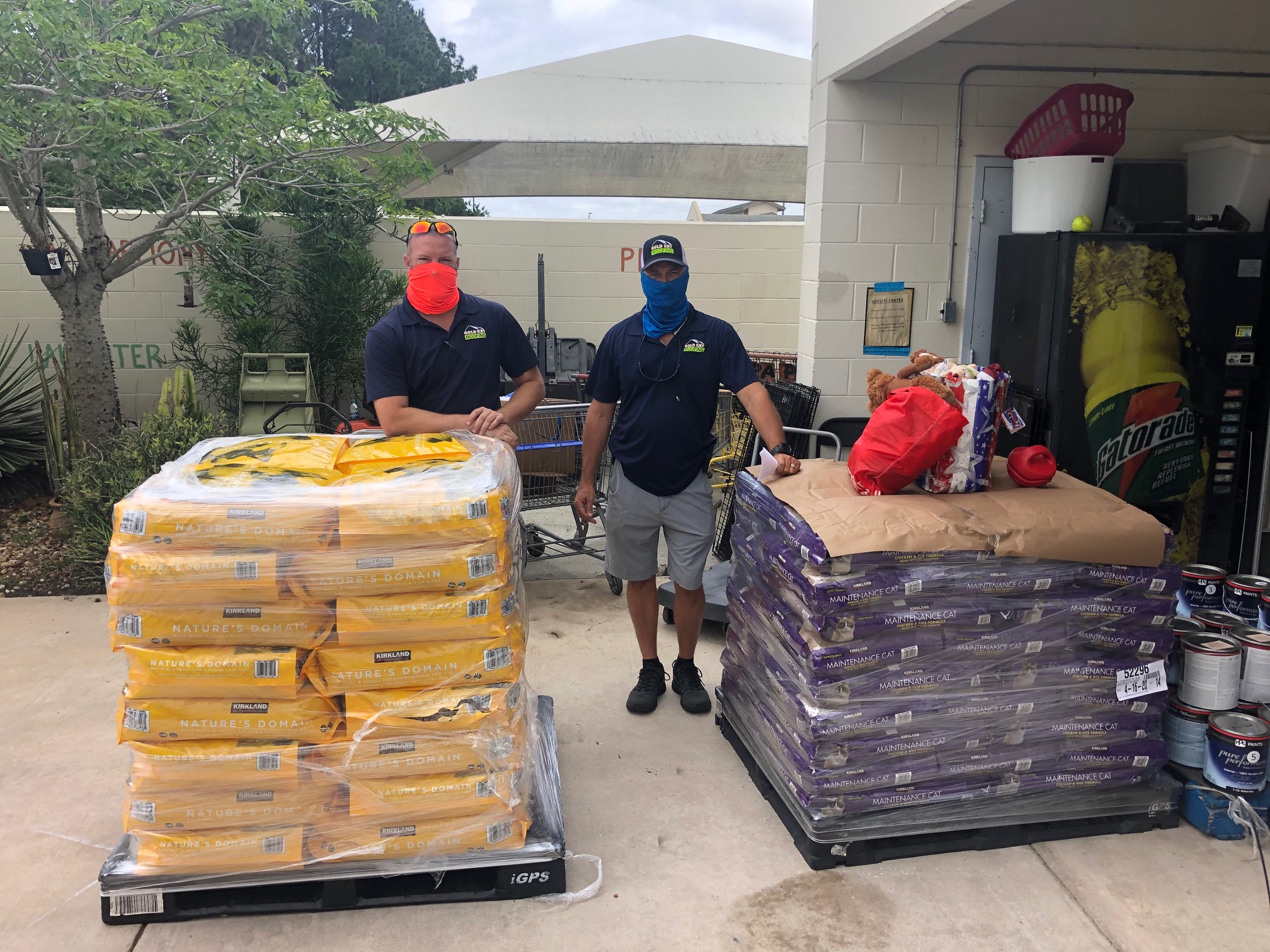 Gold Key Roofing owners with pallets of pet food